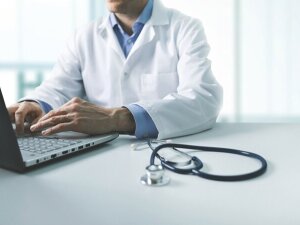 online medical consultation - doctor working on laptop computer in clinic office. copy space
